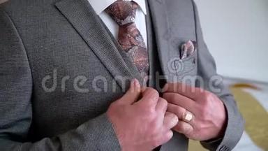 穿西装的商人把扣子系在夹克上。 男士双手扣紧夹克
